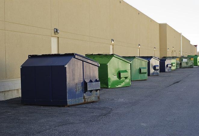 a truck unloading construction waste into a dumpster in Butte, MT